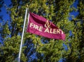 Flag in wind reading `Fire Alert`with aspen trees in background